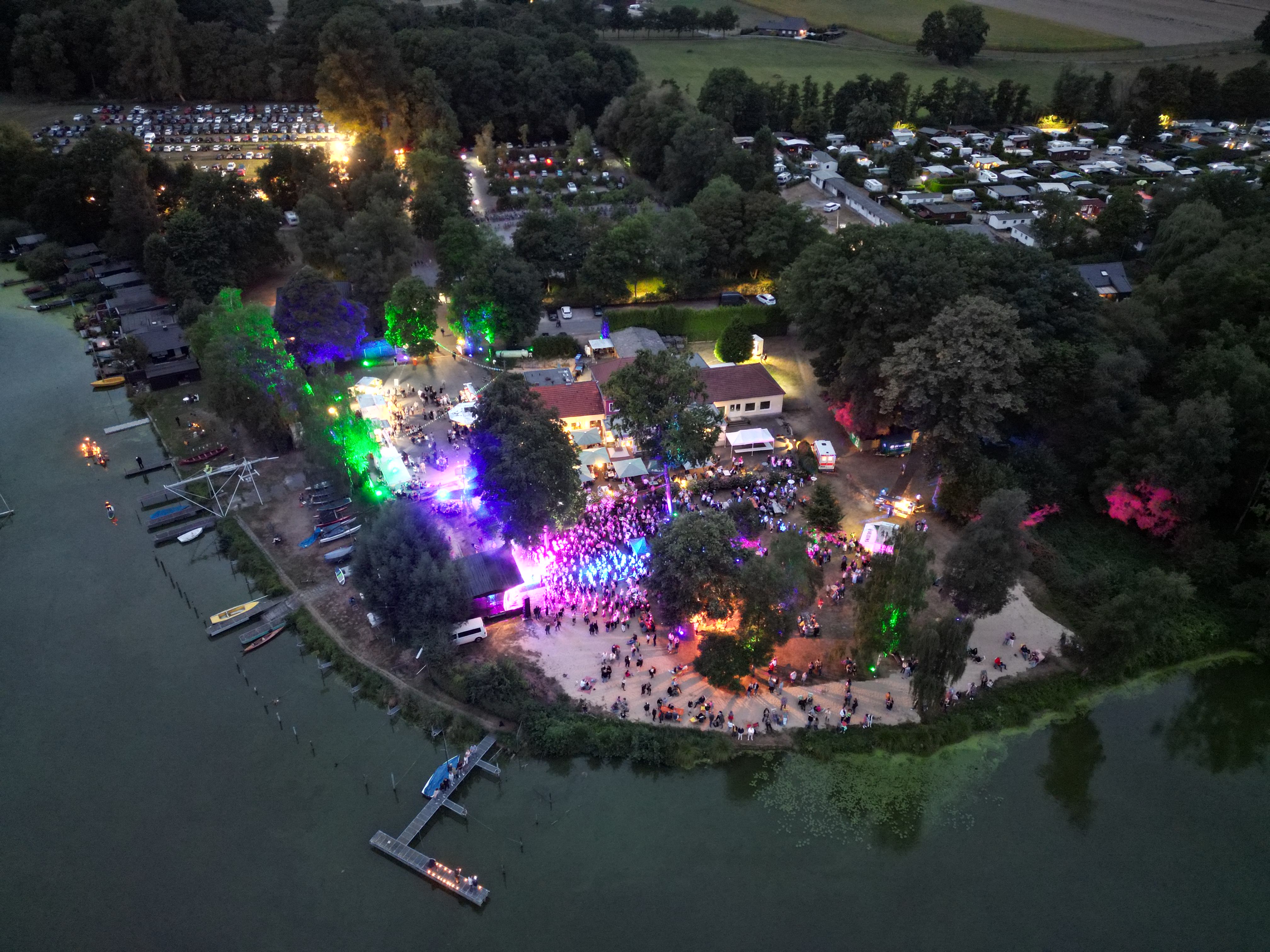 Drohnenblick auf Veranstaltungsgelände mit Bühne in der Abenddämmerung