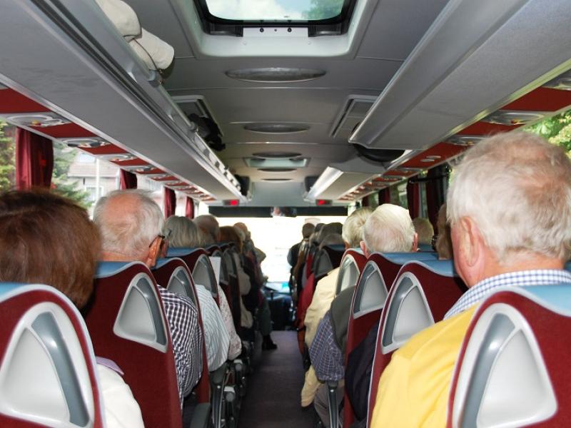 Teilnehmer einer Stadtrundfahrt im Bus sitzend 