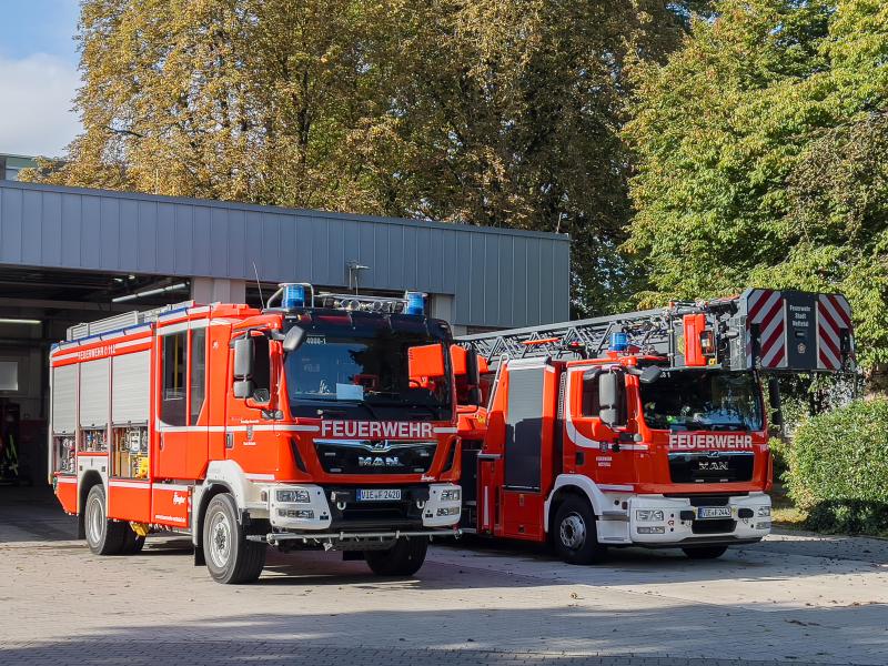 zwei Feuerwehrautos stehen geparkt vor dem Feuerwehrgebäude