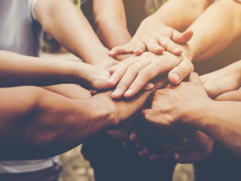 Hände von mehrerer Menschen liegen übereinander