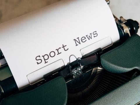 Schreibmaschine mit einem Papierblatt mit dem Text Sport News