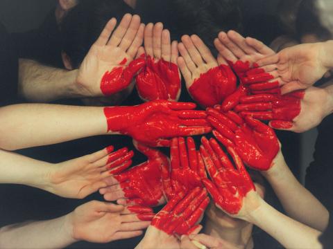 viele Hände bilden ein rotes Herz