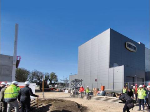 Personen auf einer Baustelle beim offiziellen Spatenstich