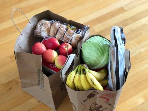 Obst, Gemüse und Brötchen in zwei Einkaufstüten